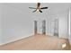 Bright bedroom featuring hardwood floors, a ceiling fan, and access to a walk-in closet and a bathroom at 157 Shadburn Ferry Rd, Buford, GA 30518