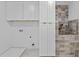 Convenient laundry room with front loading washer, dryer, cabinets, and stylish tiling, designed for ease of use at 157 Shadburn Ferry Rd, Buford, GA 30518