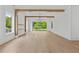 Spacious living room with wood floors, beams, modern light fixture, and large window at 157 Shadburn Ferry Rd, Buford, GA 30518