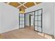 Spacious home office featuring stylish lighting fixtures, hardwood floors, and glass pane doors at 157 Shadburn Ferry Rd, Buford, GA 30518