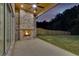 Covered patio with a brick fireplace and ceiling fan provides evening relaxation overlooking the backyard at 157 Shadburn Ferry Rd, Buford, GA 30518