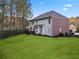 Spacious backyard featuring a lush green lawn and a patio area with views of mature trees at 3224 Wolf Club Sw Ln, Atlanta, GA 30349