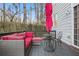 Relaxing outdoor deck with comfortable seating, an umbrella, and wooded surroundings at 3224 Wolf Club Sw Ln, Atlanta, GA 30349