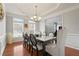 Elegant dining room with tray ceiling, natural light, and hardwood floors, perfect for entertaining and Gathering meals at 3224 Wolf Club Sw Ln, Atlanta, GA 30349