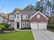 Beautiful brick two-story home with a two-car garage, manicured lawn, and lush landscaping at 3224 Wolf Club Sw Ln, Atlanta, GA 30349