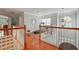 Open hallway with hardwood floors, a railing, and a decorative mirror, creating an elegant transition space at 3224 Wolf Club Sw Ln, Atlanta, GA 30349