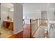 Bright hallway with wood floors featuring a stairway and a bathroom with wood cabinets and dual sinks at 3224 Wolf Club Sw Ln, Atlanta, GA 30349