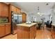 Eat-in kitchen features wood cabinets, an island, stainless steel appliances, and hardwood floors at 3224 Wolf Club Sw Ln, Atlanta, GA 30349