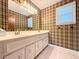 Quaint bathroom with a classic vanity, unique wallpaper, and a well-lit mirror at 8710 Mount Rushmore Dr, Johns Creek, GA 30022