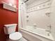 Bright bathroom featuring a tiled shower-tub combination with jacuzzi jets and red accent wall at 8710 Mount Rushmore Dr, Johns Creek, GA 30022