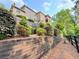 Beautiful multi-story home with landscaped retaining wall and view of nature at 8710 Mount Rushmore Dr, Johns Creek, GA 30022