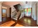 Warm and inviting foyer featuring hardwood floors, staircase, and decorative glass-paneled doors at 8710 Mount Rushmore Dr, Johns Creek, GA 30022