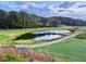 Scenic golf course view with lush green fairways, a tranquil pond, and beautiful trees at 8710 Mount Rushmore Dr, Johns Creek, GA 30022