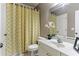 Bathroom features a white vanity, patterned shower curtain, and decorative orchid for a clean and stylish space at 931 Hidden Falls Se Ln, Smyrna, GA 30082
