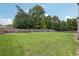 Green back yard bordered by a tall wood fence and mature trees at 3126 Cove View Ct, Dacula, GA 30019