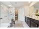 This is a bathroom with a glass shower, marble tile, and double sinks at 3126 Cove View Ct, Dacula, GA 30019