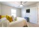 Bright bedroom featuring a ceiling fan, window, and a bed with white bedding and yellow throw pillows at 3126 Cove View Ct, Dacula, GA 30019