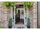 Inviting entryway featuring a decorative front door, brick accents and decorative plants at 3126 Cove View Ct, Dacula, GA 30019