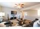 This is a living room with a television, a ceiling fan, carpet, and leather couches at 3126 Cove View Ct, Dacula, GA 30019