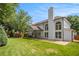 Expansive backyard featuring a covered patio, large windows, and manicured lawn at 300 Windsor Chase Trl, Johns Creek, GA 30097