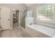 This bathroom features a soaking tub, glass enclosed shower, and a walk in closet space at 300 Windsor Chase Trl, Johns Creek, GA 30097