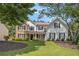 Charming two-story home featuring stone accents, white siding, and a well-manicured front yard at 300 Windsor Chase Trl, Johns Creek, GA 30097