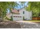 A charming home showcases a two-car garage, white siding, and a well-maintained driveway at 300 Windsor Chase Trl, Johns Creek, GA 30097