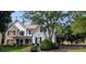 Inviting two-story home featuring a combination of stone and siding, complemented by lush greenery at 300 Windsor Chase Trl, Johns Creek, GA 30097