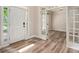Bright foyer with wood-look flooring, white trim, and a view into the adjacent room through glass French doors at 300 Windsor Chase Trl, Johns Creek, GA 30097