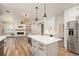 Open concept kitchen with center island, leading to a fireplace in the living room at 300 Windsor Chase Trl, Johns Creek, GA 30097