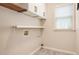 Laundry room with a small window, open shelving, and gray flooring at 300 Windsor Chase Trl, Johns Creek, GA 30097