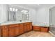 Bathroom featuring double sinks, large mirror, soaking tub and shower with glass doors and tile flooring at 1717 N Decatur Ne Rd # 117, Atlanta, GA 30307