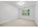 Neutral bedroom featuring plush carpeting, white paint, white trim, and a window with plantation shutters at 1717 N Decatur Ne Rd # 117, Atlanta, GA 30307