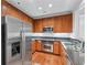 Well-equipped kitchen with stainless steel appliances, granite countertops, and light brown wood cabinets at 1717 N Decatur Ne Rd # 117, Atlanta, GA 30307