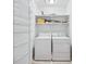 A clean laundry room with modern white washer and dryer, along with shelves for storage at 1717 N Decatur Ne Rd # 117, Atlanta, GA 30307
