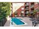 Outdoor swimming pool surrounded by brick buildings with balconies, lounge chairs, and lush landscaping at 1717 N Decatur Ne Rd # 117, Atlanta, GA 30307