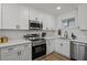 Modern kitchen features white cabinets, stainless steel appliances, and light countertops at 3634 Oakleaf Pass, Fairburn, GA 30213