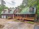 Picturesque log cabin featuring a connecting garage, wood porch, and green roof at 519 E Valley Ne Rd, Rydal, GA 30171