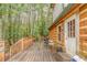 Wood porch with a railing and chairs next to a side entrance into a log cabin at 519 E Valley Ne Rd, Rydal, GA 30171