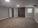 A finished basement featuring painted walls, a brick accent wall, a window and carpeted flooring at 8291 Highway 5, Whitesburg, GA 30185