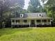 Charming one-story home features a covered front porch and dormer windows amidst mature trees at 8291 Highway 5, Whitesburg, GA 30185