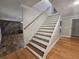 A classic staircase design with a wood handrail and combination of carpet and hardwood flooring at 8291 Highway 5, Whitesburg, GA 30185