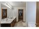 Bathroom featuring double sinks, a large mirror, dark cabinets and walk-in closet at 893 Whitfield Oak Rd, Auburn, GA 30011