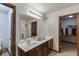 Bathroom featuring double sinks, a large mirror, dark cabinets, shower and two walk-in closets at 893 Whitfield Oak Rd, Auburn, GA 30011