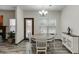 Bright dining area featuring a round table, white chairs, and a view of the backyard at 893 Whitfield Oak Rd, Auburn, GA 30011