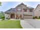 Charming two-story home with brick and siding, a well-manicured lawn, and solar panels on the roof at 893 Whitfield Oak Rd, Auburn, GA 30011