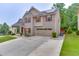 Two-story home featuring brick and siding exterior, an attached garage, and a well-kept front yard at 893 Whitfield Oak Rd, Auburn, GA 30011