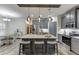 Bright kitchen featuring gray cabinets, a granite island with seating, and stainless steel appliances at 893 Whitfield Oak Rd, Auburn, GA 30011