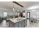 Open concept kitchen with granite island and seating, stainless steel appliances, flowing into the living and dining areas at 893 Whitfield Oak Rd, Auburn, GA 30011