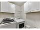Laundry room featuring a white washer and dryer, cabinets, and laundry accessories at 893 Whitfield Oak Rd, Auburn, GA 30011